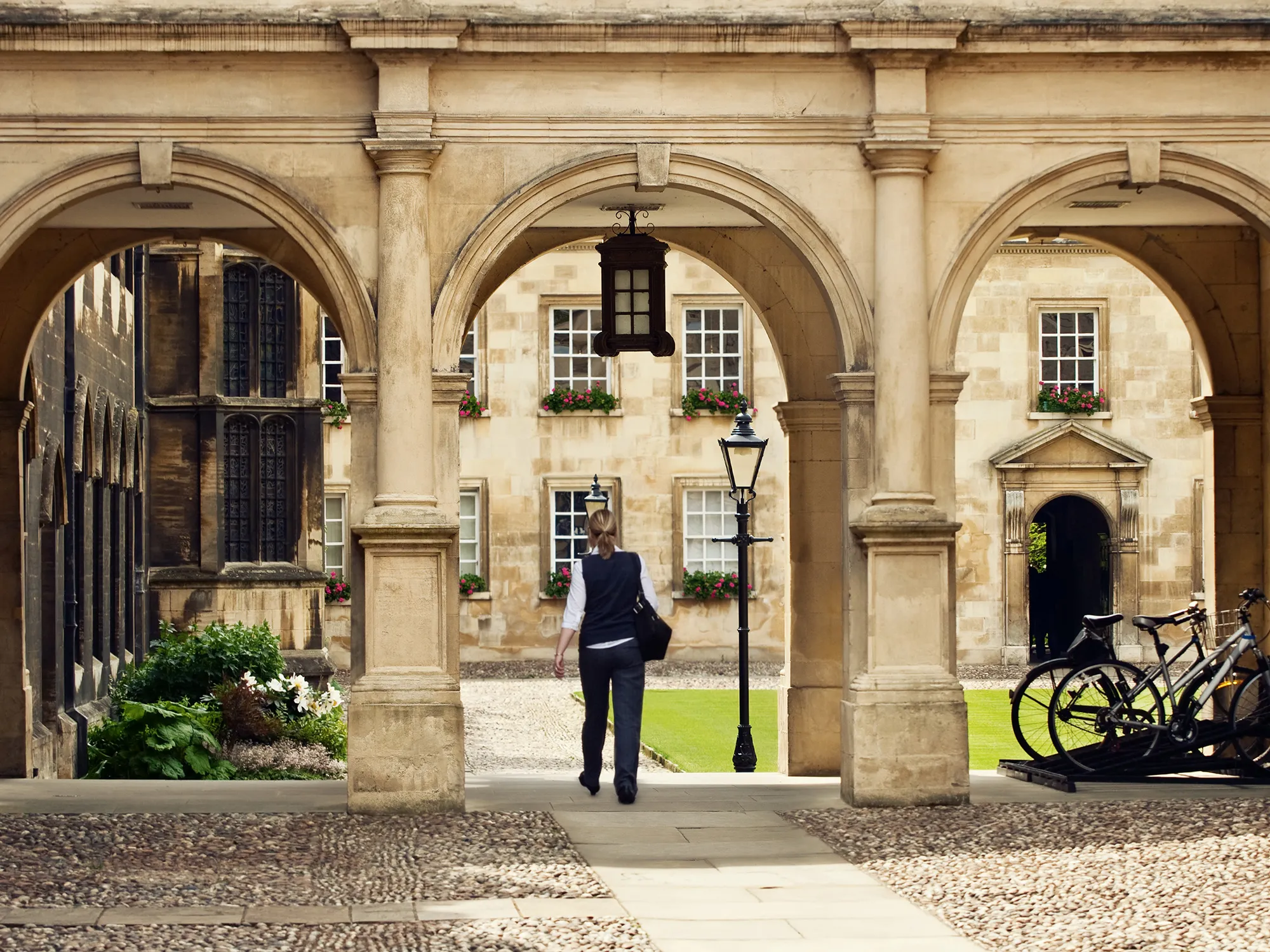 Student passing through a college campus in Cambridge Universitiy, UK