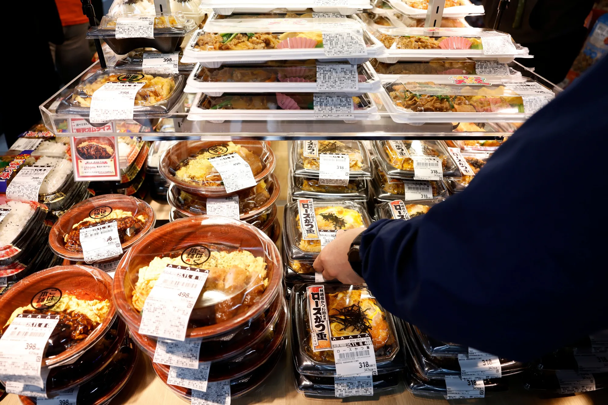 Packages of breaded pork loin cutlet on rice at a Trial Go store in Tokyo.