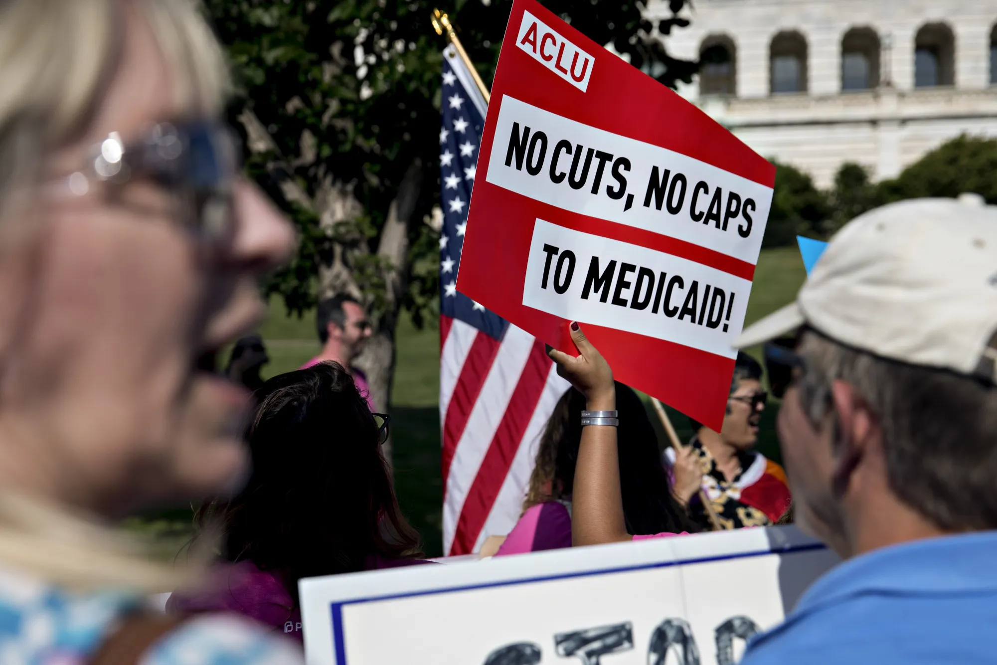 A demonstrator holds a sign protesting proposed Medicaid cuts near the US Capitol in 2017.