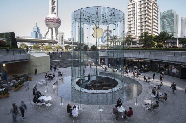People dine near the entrance of an Apple store during lunch hour in the Lujiazui Financial District in Shanghai on March 20. Photographer: Qilai Shen/Bloomberg