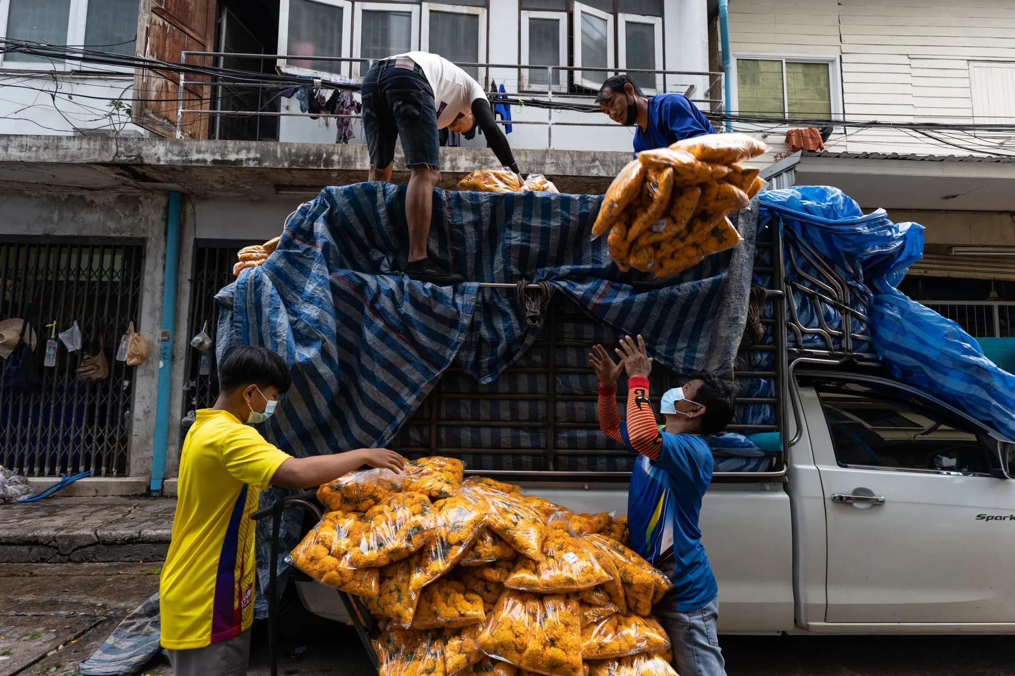 Workers unload flowers from a truck at a market in Bangkok.