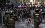 Demonstrators clash with riot police during protests against the government economic policies, in the surroundings of La Moneda presidential palace in Santiago, on Oct. 29, 2019.