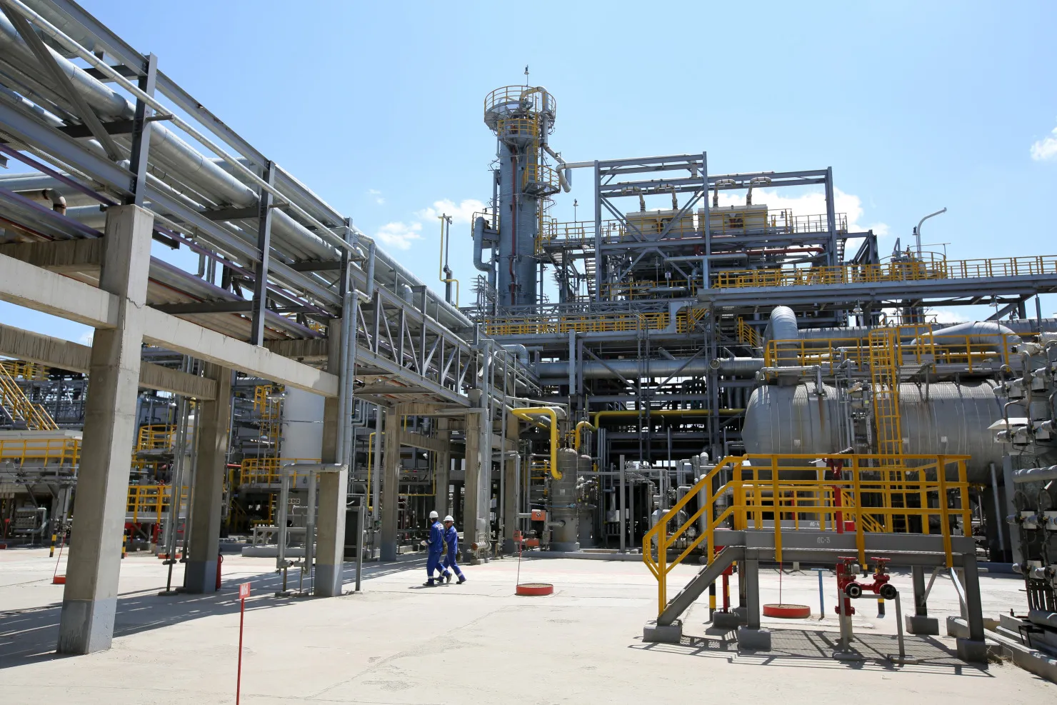 Workers walk through the processing complex at an&nbsp;oil refinery in Atyrau, Kazakhstan.