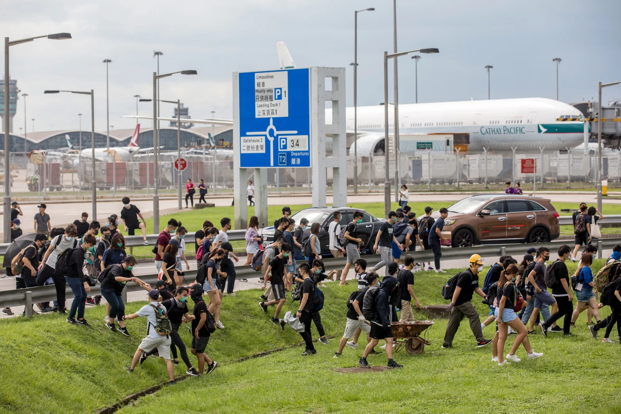 A Cathay Pacific Airways aircraft sits at Hong Kong International Airport&nbsp;as protesters climb across a road divider in Hong Kong, on Sept. 1.