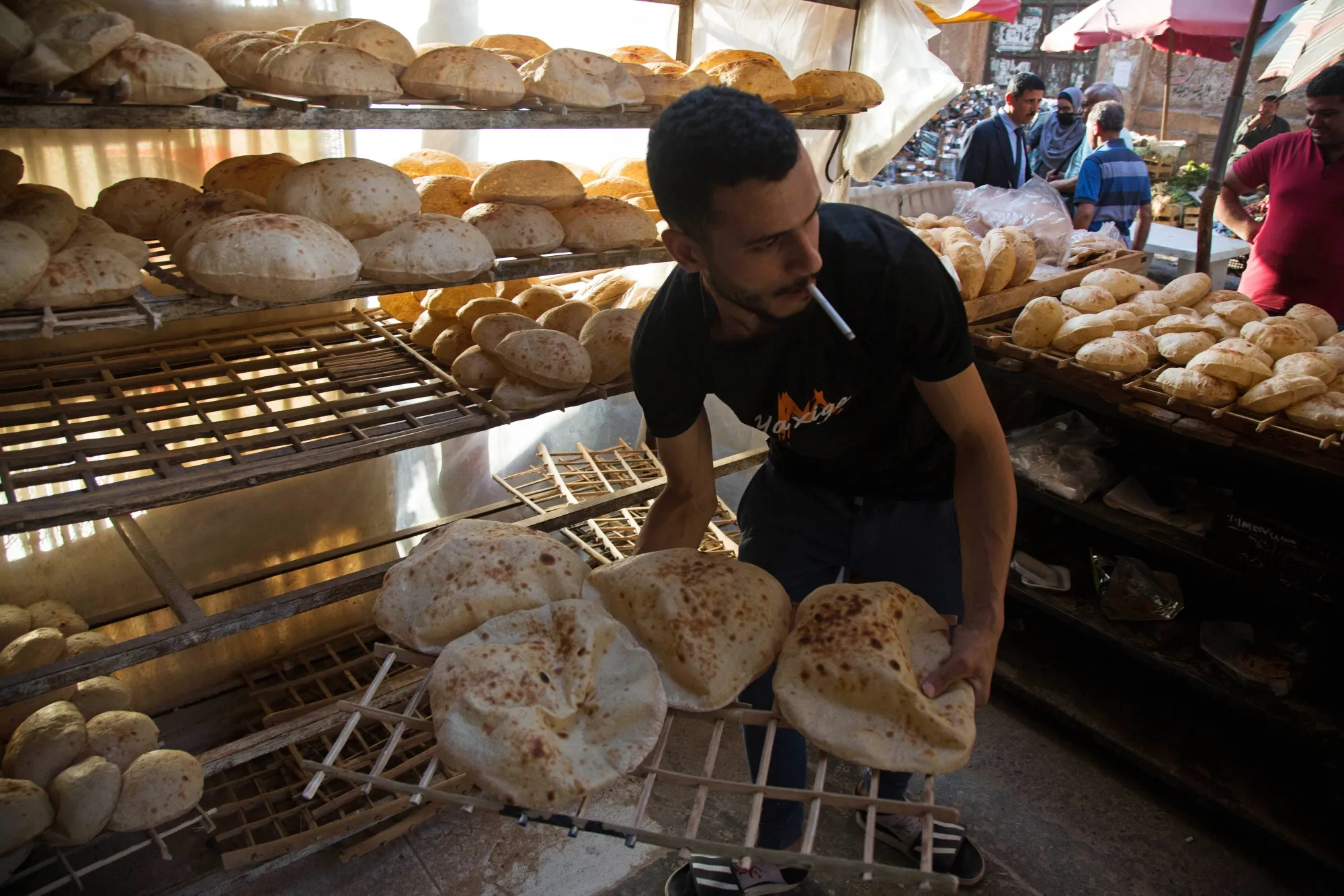 A worker arranges freshly baked bread for sale at the Al-Monira market in Cairo.