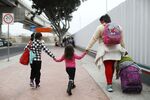 A migrant mother walks with children in Tijuana, Mexico.