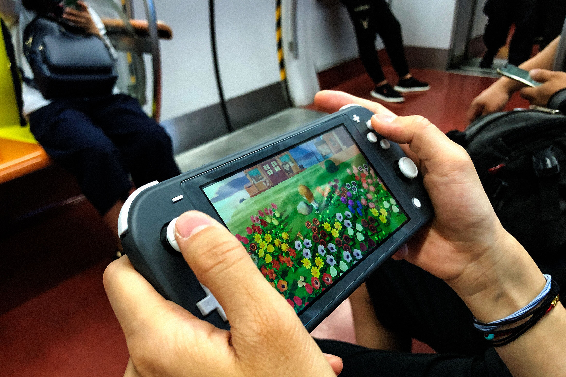 Students play online games inside a subway train in Beijing