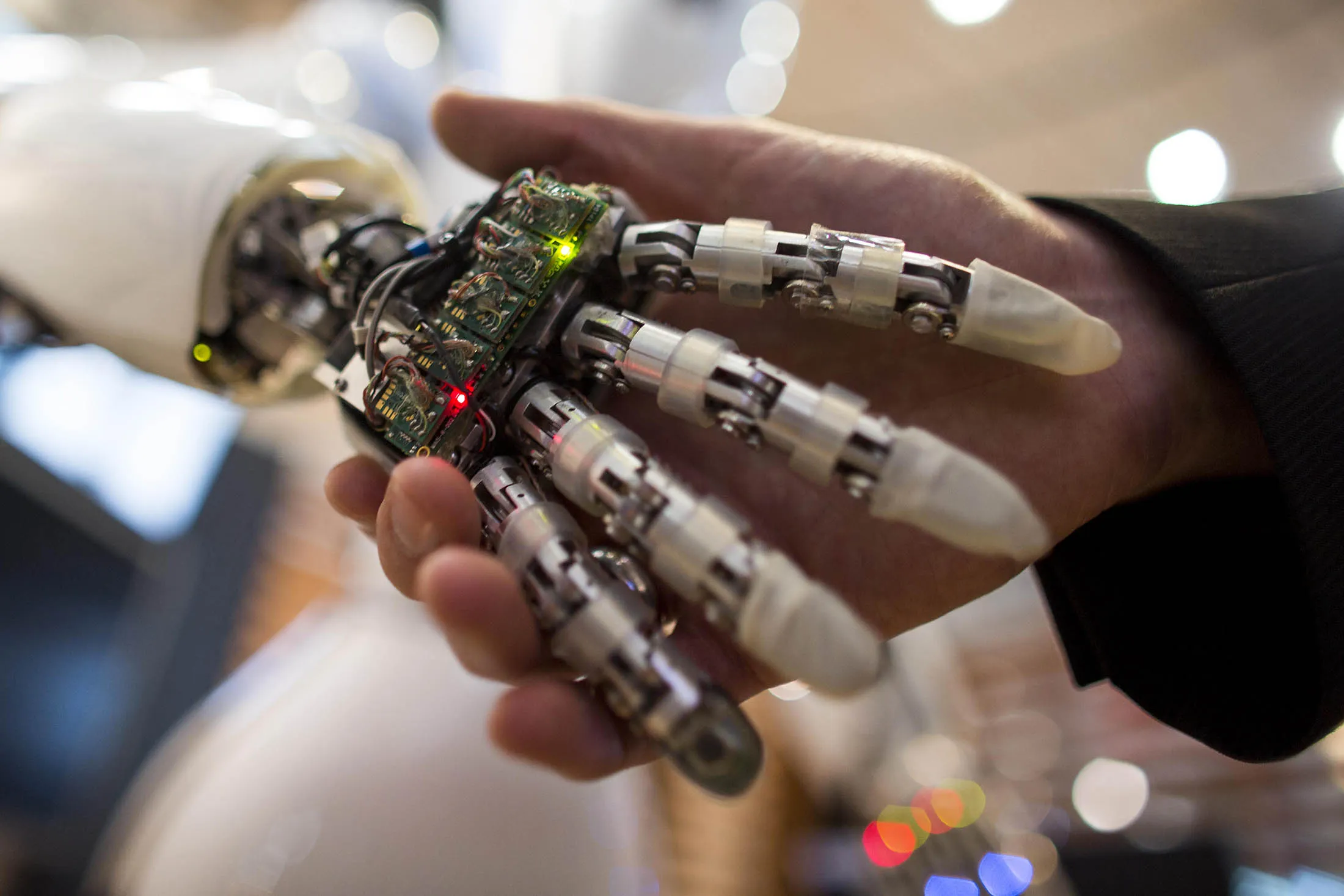 A visitor holds a hand of AILA, or Artificial Intelligence Lightweight Android, during a demonstration at the German Research Center for Artificial Intelligence GmbH (Deutsches Forschungszentrum fuer Kuenstliche Intelligenz GmbH) stand at the 2013 CeBIT technology trade fair on March 5, 2013 in Hanover, Germany. CeBIT will be open March 5-9. AFP PHOTO / CARSTEN KOALL (Photo credit should read CARSTEN KOALL/AFP/Getty Images)
