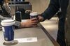 An employee, left, serves a coffee beverage to a customer at a Luckin Coffee outlet in Beijing, China, on Tuesday, Jan. 15, 2019. Luckin, the Chinese startup that's banking on selling cappuccinos to on-the-go office workers, is spending millions of dollars a year opening outlets to unseat Starbucks Corp. as the top java seller in the country.