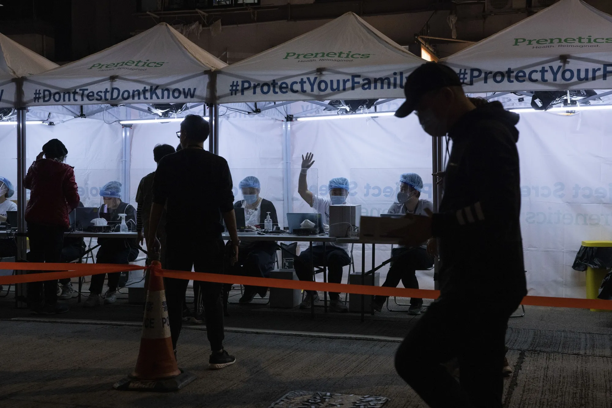 Health workers assist residents to take Covid-19 tests outside a building placed under lockdown in the North Point district in Hong Kong, on&nbsp;Jan. 6.&nbsp;