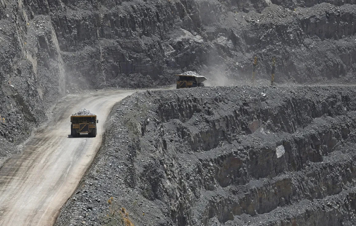 Mining trucks ferry diamond-bearing kimberlite rock away from the excavation area of Jwaneng mine, operated by the Debswana Diamond Co., a joint venture between De Beers and Botswana's government, in Jwaneng, Botswana.