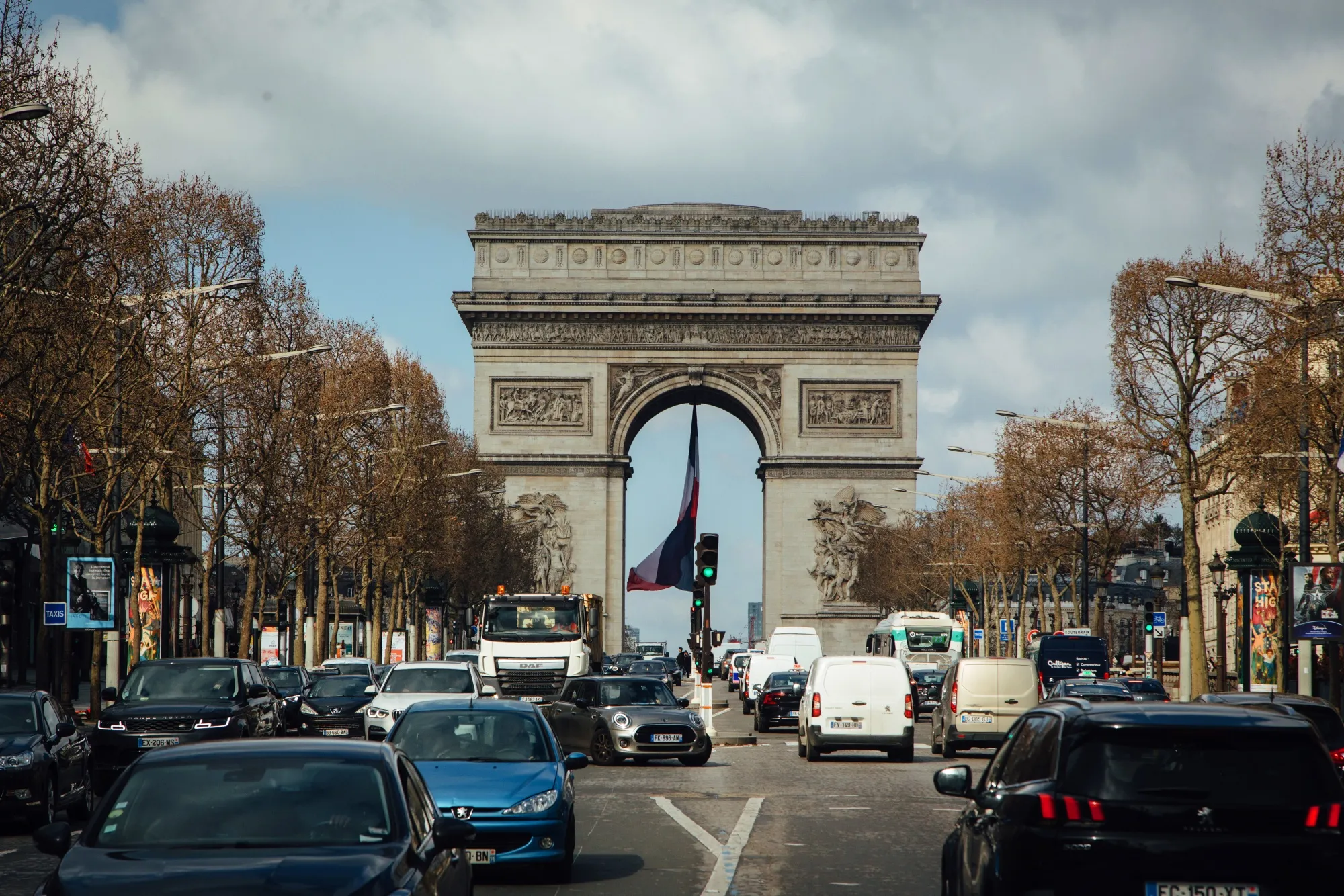Traffic passes along the Champs Elysee avenue near the Arc de Triomph in Paris, France.