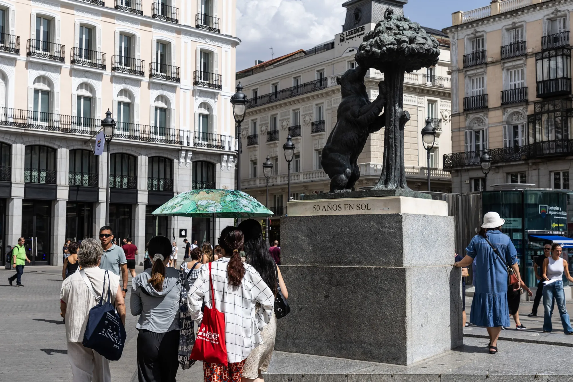 Pedestrians use an umbrella to shield themselves from the sun&nbsp;during high temperatures in Madrid on June 20.