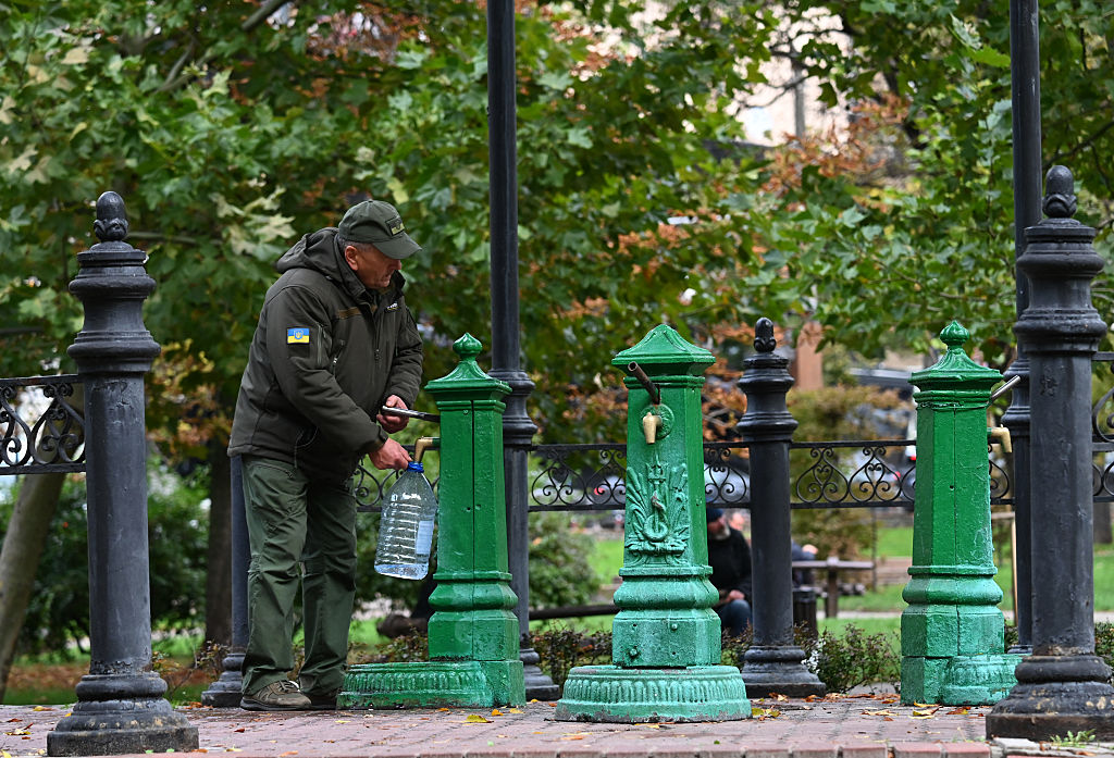 A Ukrainian serviceman fills a bottle with water from a pump as Russian attacks in Kyiv cut power and water supply. Photographer: Sergei Supinsky&#x2F;AFP&#x2F;Getty Images