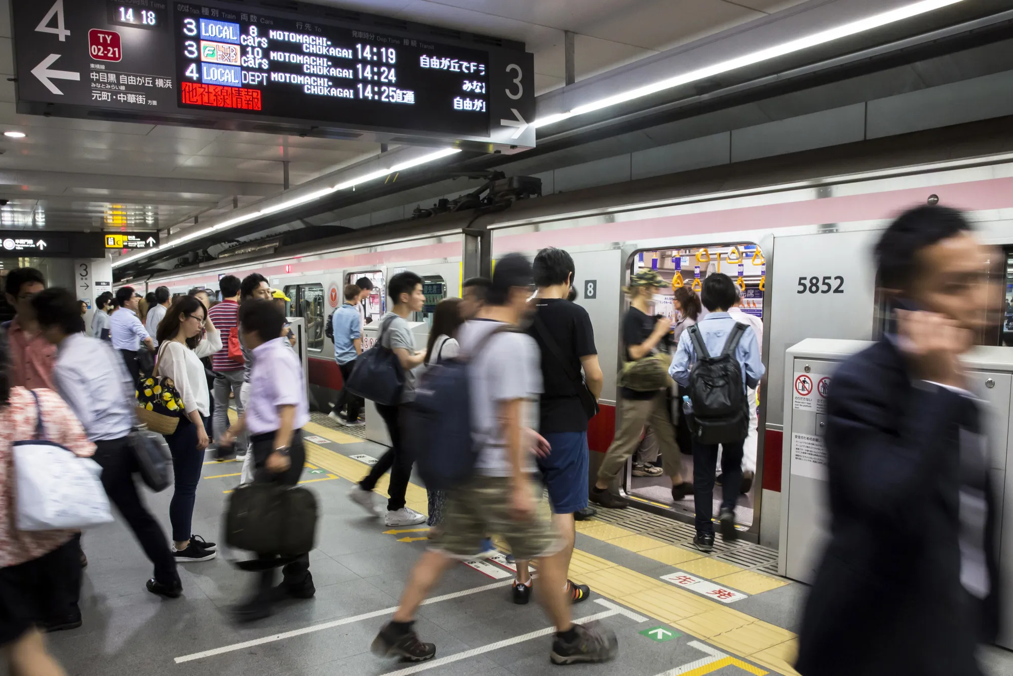 Passengers board a train on the Toyoko line operated by Tokyu Corp. at Shibuya Station in Tokyo, Japan, on Tuesday, July 18, 2017. July 24 marks the first dry run of a 'Telework Day' encouraging people to work from home as the city gears up to host the 2020 Summer Olympics. Authorities are seeking ways to make room for 920,000 spectators expected to visit Tokyo each day during the games.