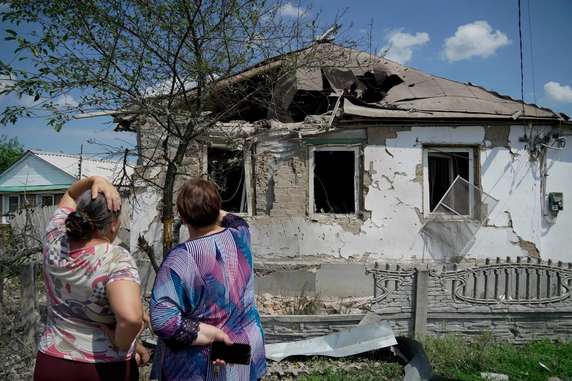 Two people look at a destroyed house in Valuyki, Ukraine on July 5.