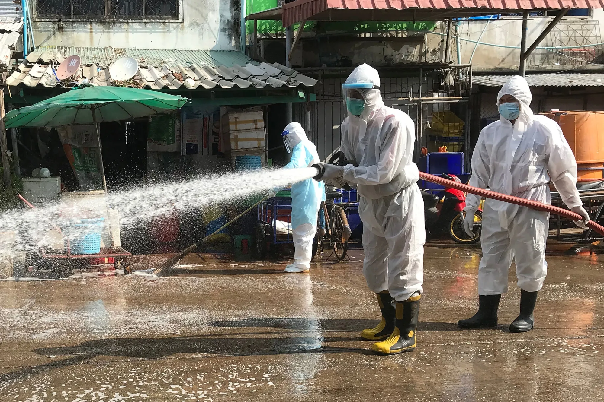 Workers spray disinfectant at the Samut Sakhon Shrimp Center market that was temporarily shut down due to several vendors testing positive for the Covid-19 coronavirus, in Samut Sakhon on Jan. 25.