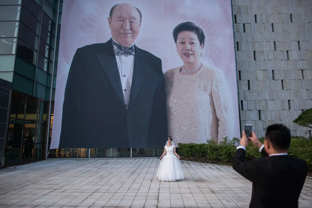 A bride poses&nbsp;before an image&nbsp;of deceased Unification Church founder&nbsp;Sun Myung-Moon and his wife, Hak Ja-Han, before a mass wedding ceremony in 2017.