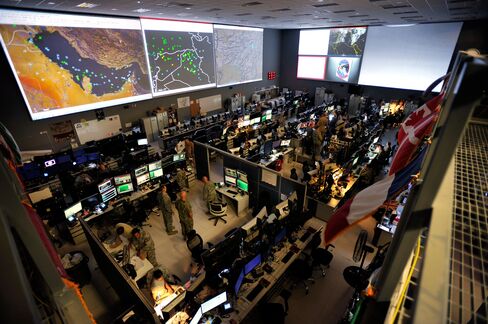 Staff monitor airborne aircraft operations in the Middle East region, including Iraq, Syria, Afghanistan, and 17 other nations via large screens from inside the the United States Air Force Combined Air and Space Operations Center (CAOC), at the Al Udeid Air Base in Qatar, in this undated handout photograph released to the media on Thursday, Oct. 8, 2015.