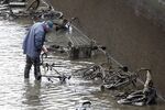 A worker inspects trash/treasure found at the bottom of the Canal Saint-Martin. 