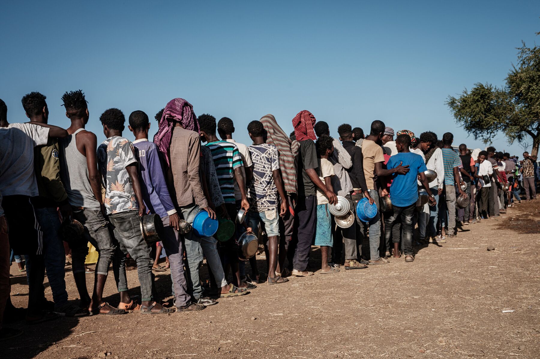 Refugees who fled the Ethiopia's Tigray conflict wait in line for food distribution at the Um Raquba refugee camp in Sudan's eastern Gedaref state on Dec. 12, 2020. 