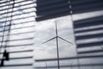 A wind turbine is seen through a window 