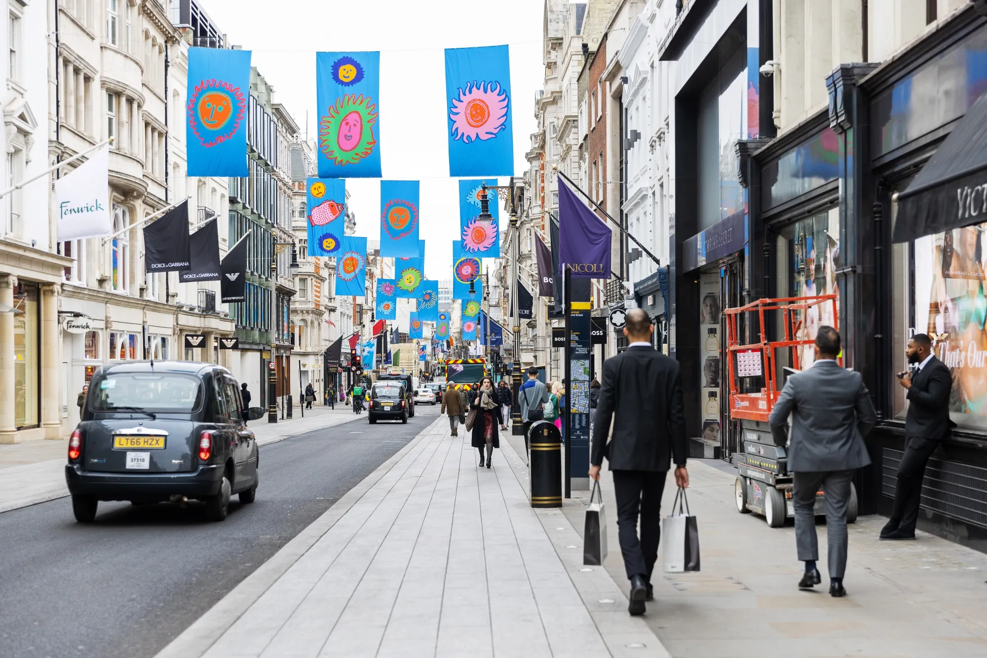 Pedestrians pass luxury stores on New Bond Street in central London, UK.