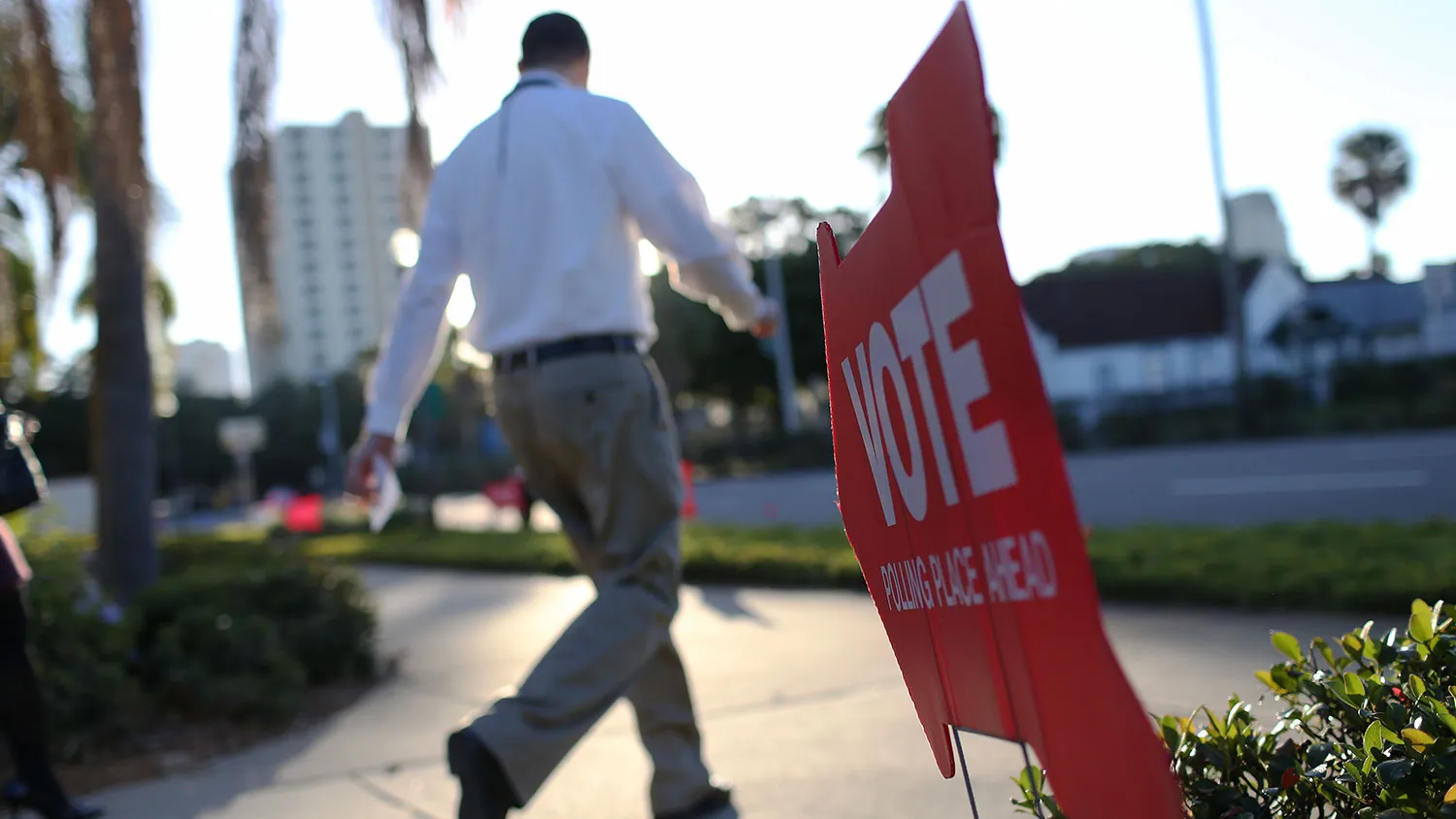 A voter walks past a sign pointing the way to a polling station on Nov. 4, 2014, in St. Petersburg, Florida.
