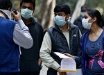 People wait outside an H1N1 Influenza screening center at the Ram Manohar Lohia Hospital in New Delhi, India on Feb. 18, 2015.
