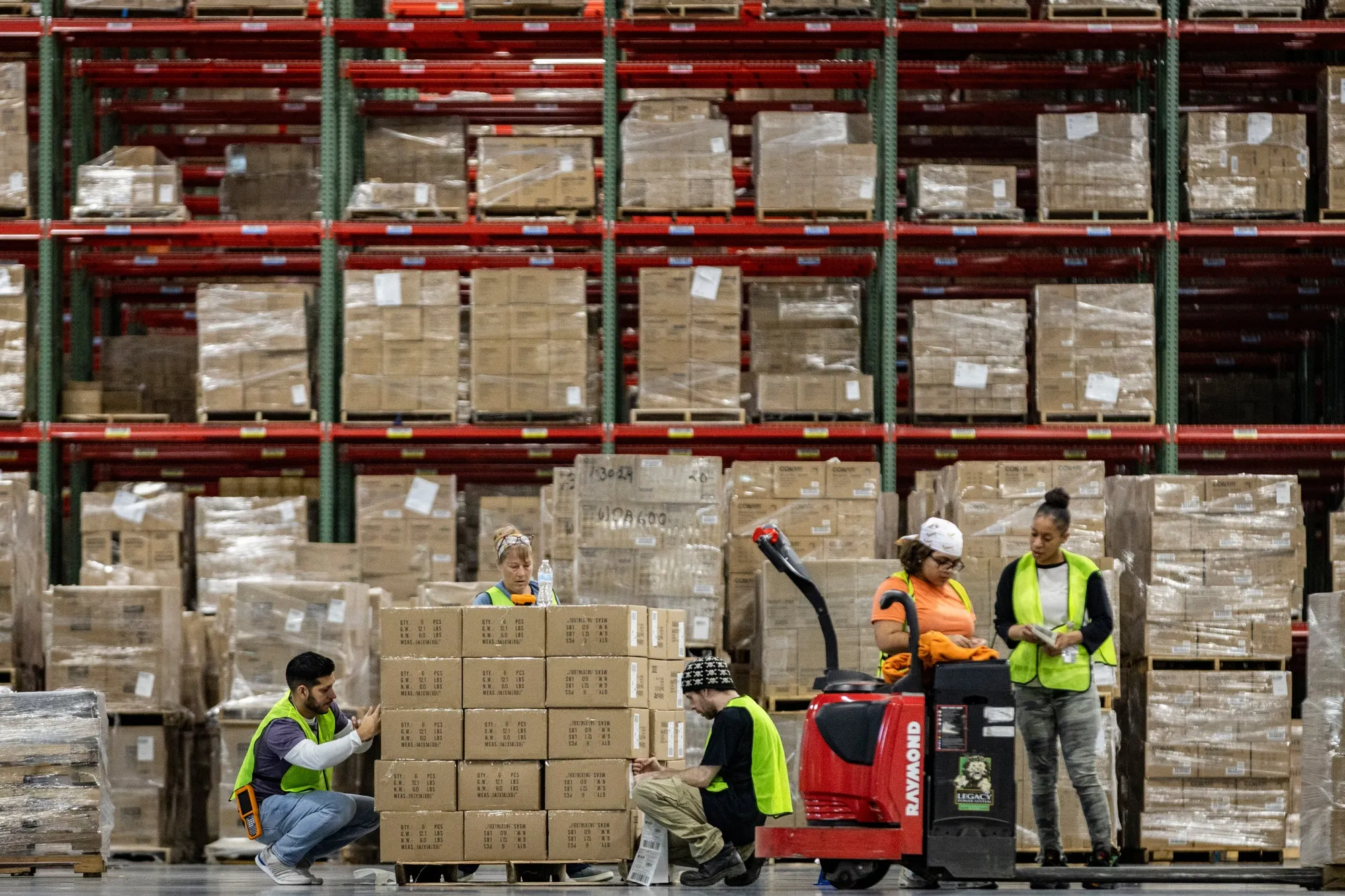 Workers apply labels to boxes.