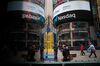 Pedestrians pass in front of the Nasdaq MarketSite in the Times Square neighborhood of New York, U.S., on Monday, April 8, 2019. U.S. stocks pared losses as investors awaited signs of progress in the trade war with China ahead of the latest corporate earnings season.