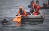 Divers bringing up bags filled with debris and body parts off the coast of Jakarta on Jan. 11.