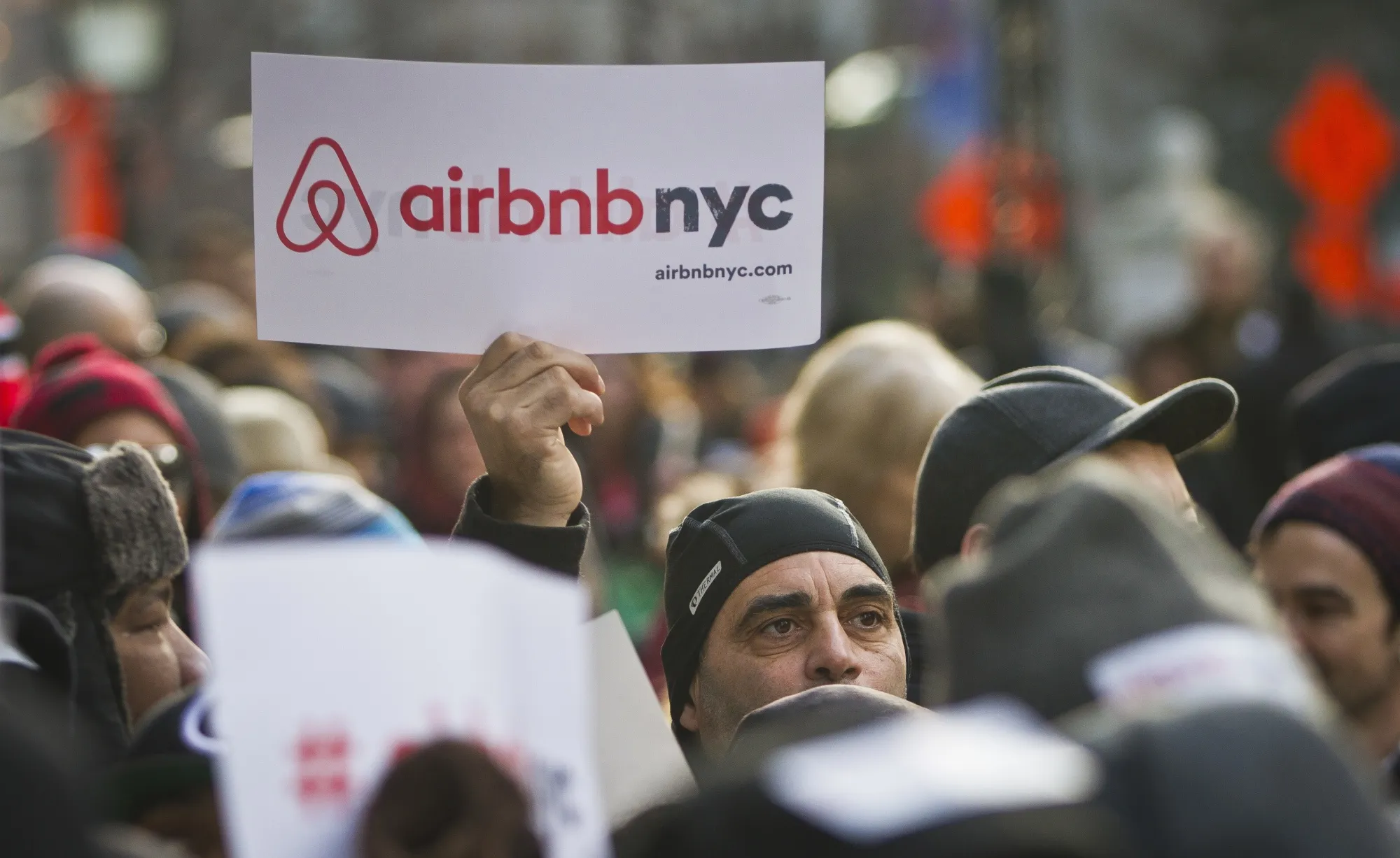 A supporter of Airbnb holds a sign outside City Hall in New York in 2015.
