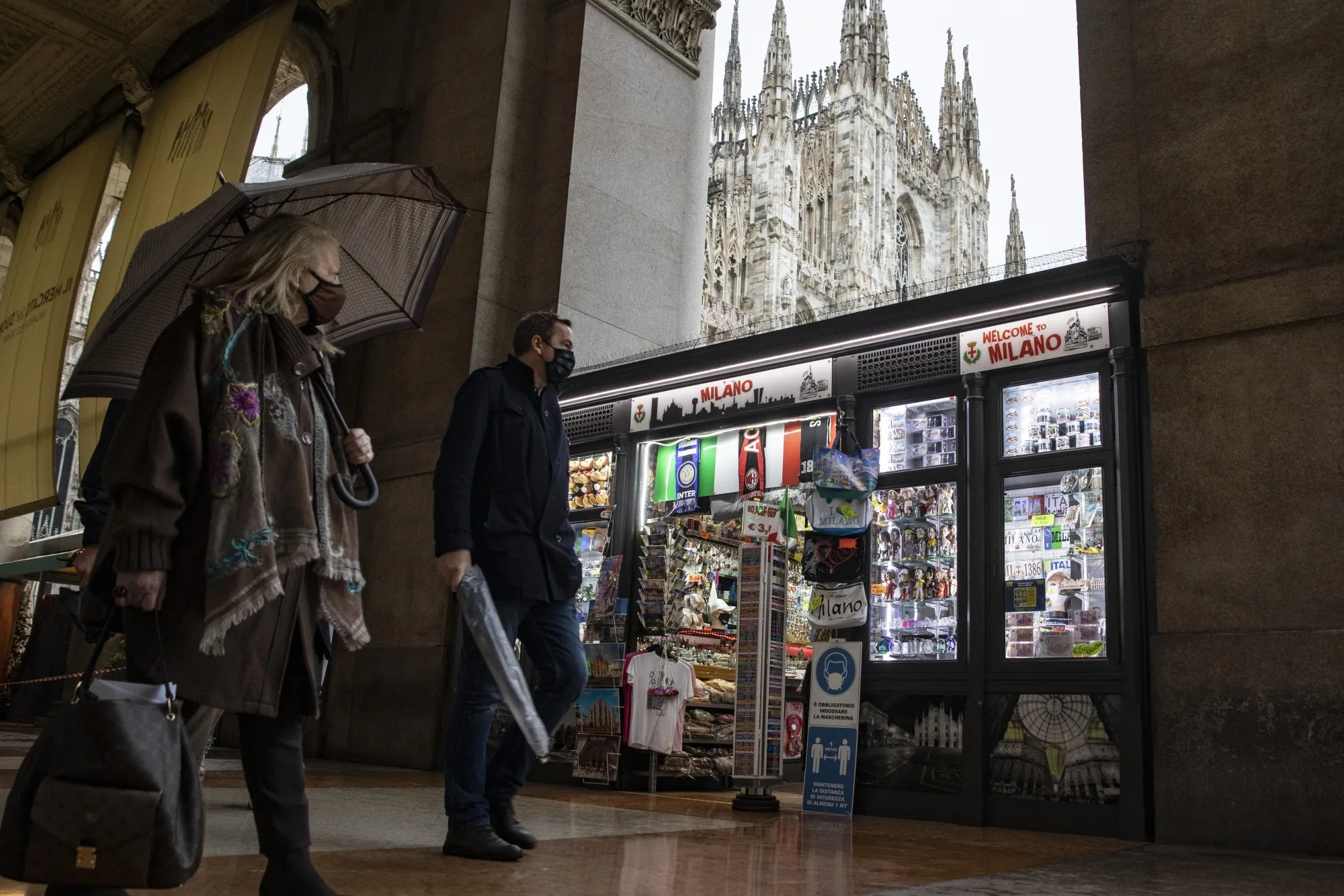 Pedestrians walk through Duomo Square in Milan.