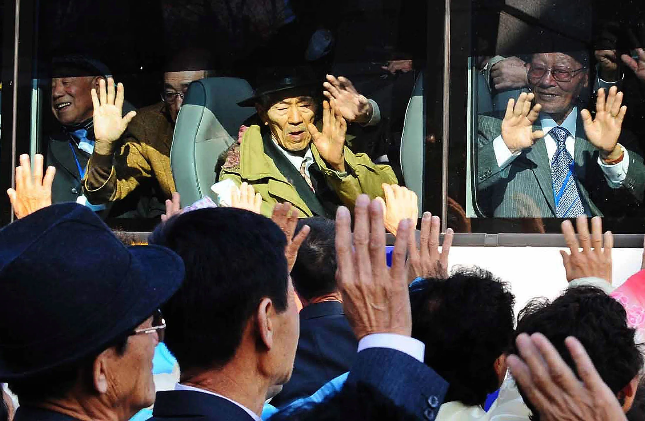 South Koreans in a bus bid farewell to their North Korean relatives before they return to their home after a family reunion in North Korea. Photographer: Getty Images
