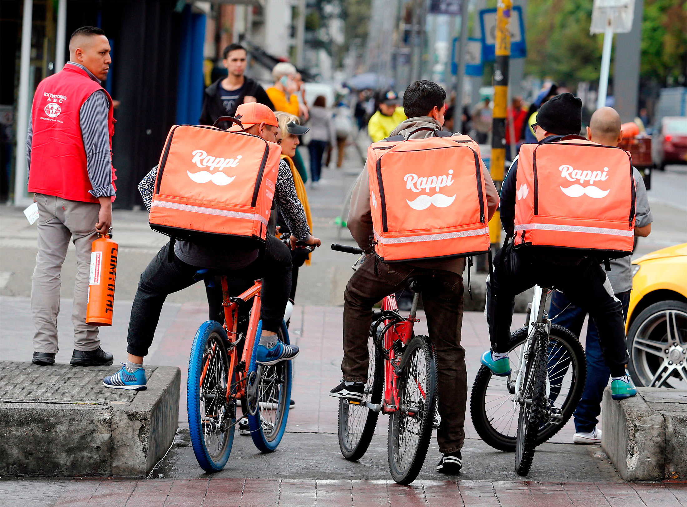 Venezuelan nationals working as bicycle couriers, for Colombian online delivery company &quot;Rappi&quot;, ride their bikes in Bogota, on October 11, 2018.