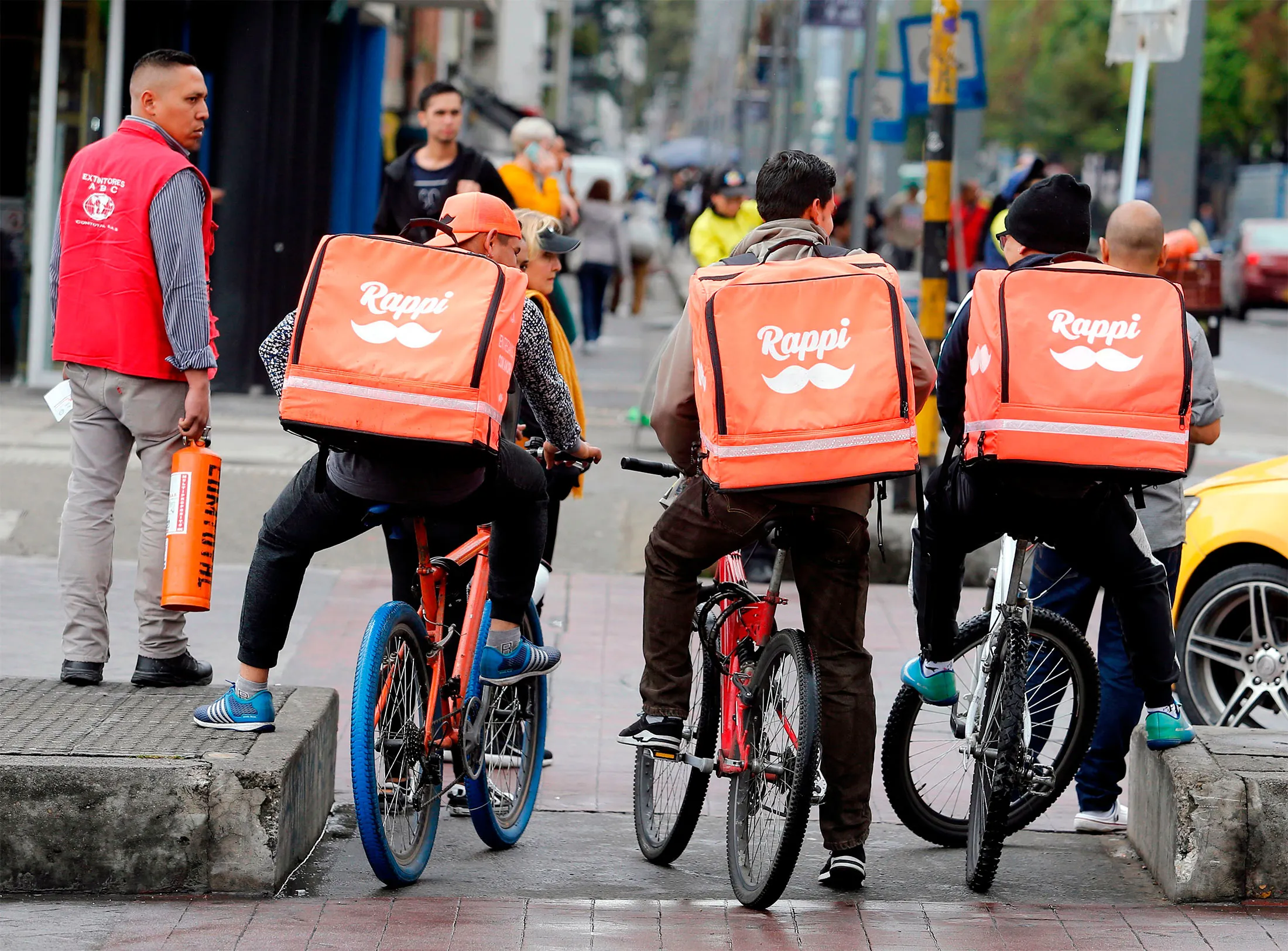 Venezuelan nationals working as bicycle couriers, for Colombian online delivery company "Rappi", ride their bikes in Bogota, on October 11, 2018.