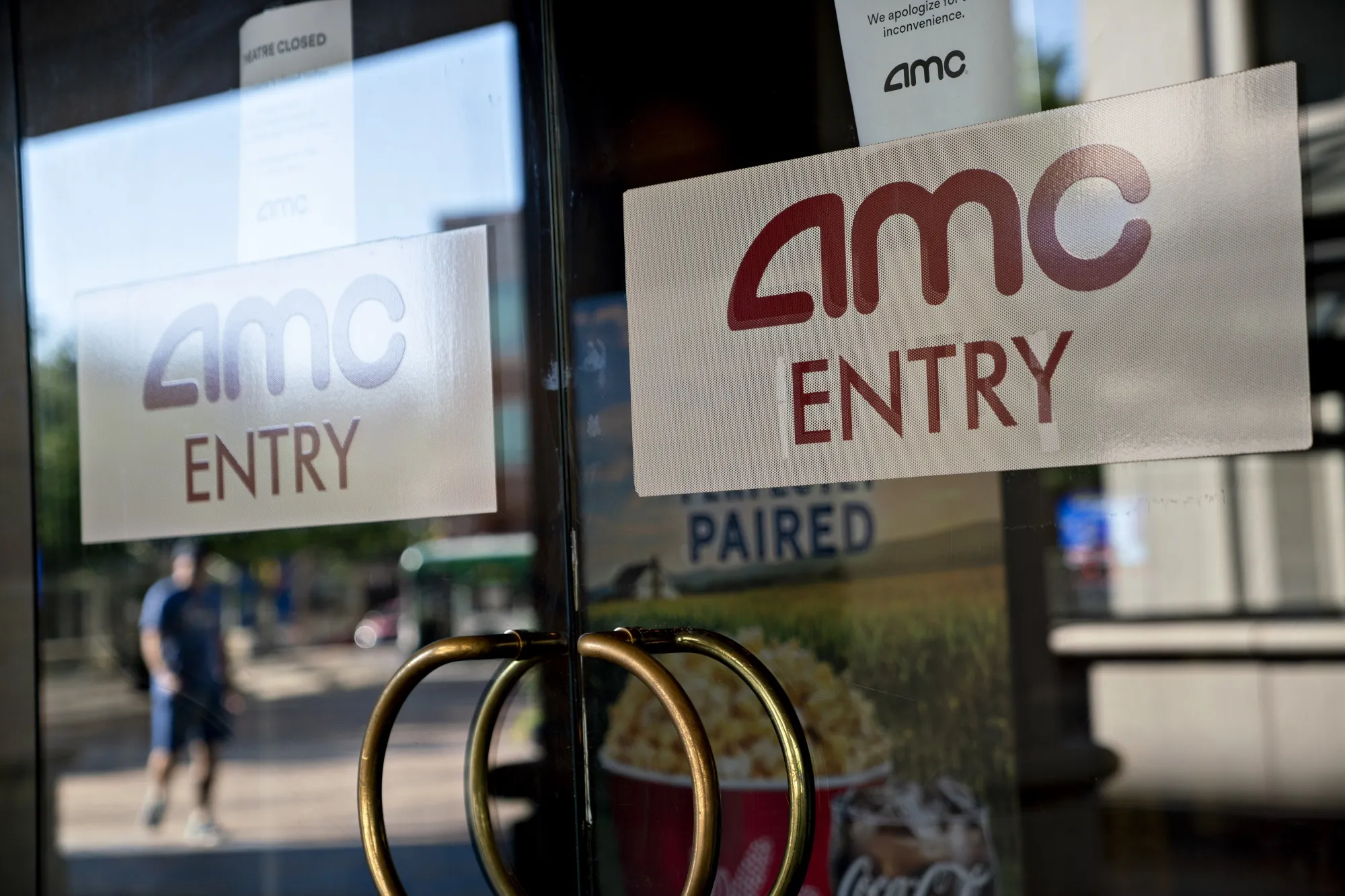 Signage is displayed on the doors of an AMC movie theater.