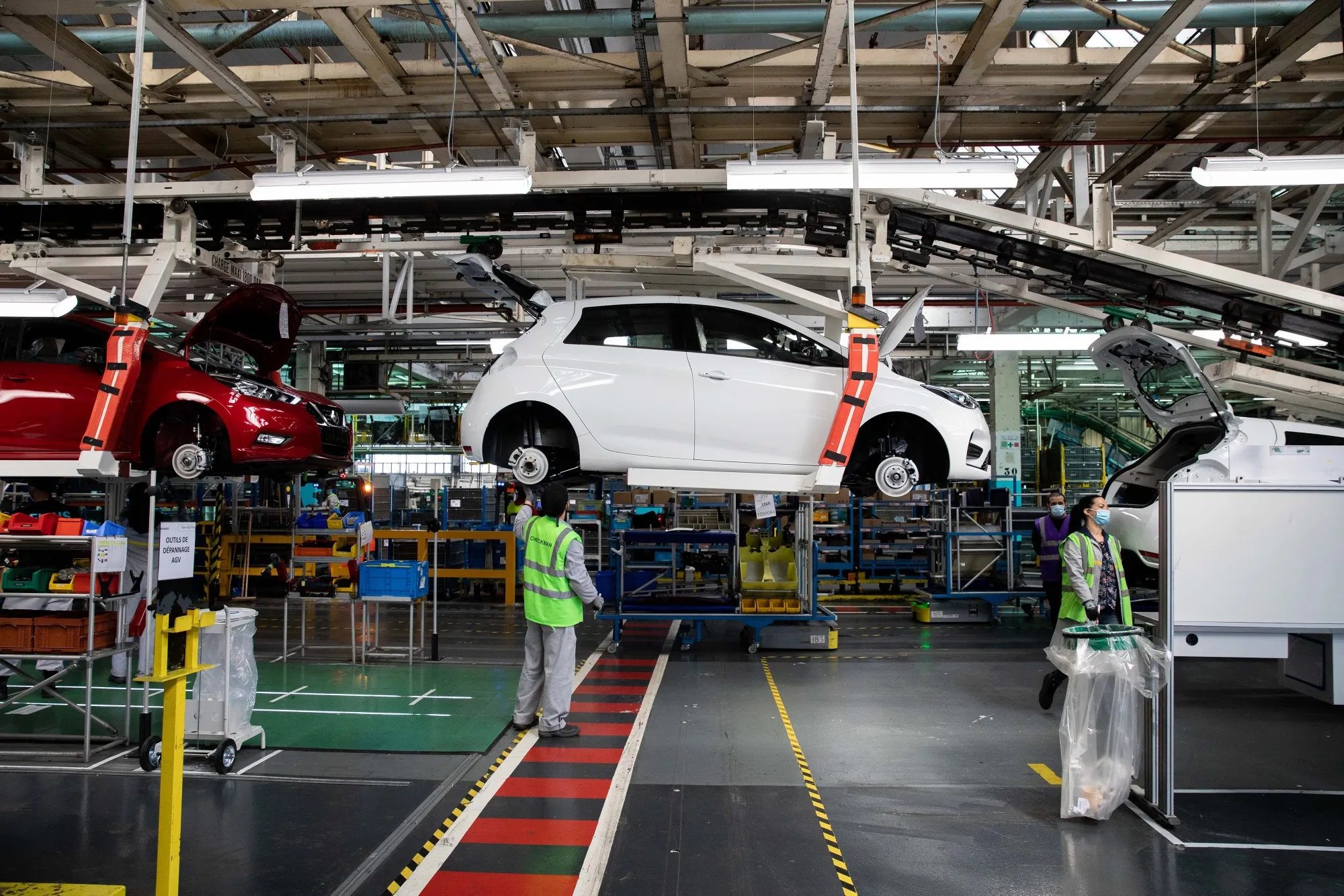 Employees work on the Renault Zoe electric automobile assembly line at the Renault SA factory in Flins, France.