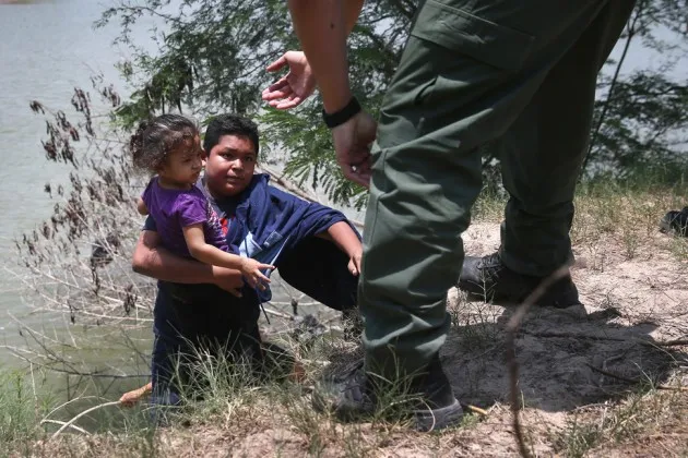A U.S. Border Patrol agent assists undocumented minors near the U.S./Mexico border