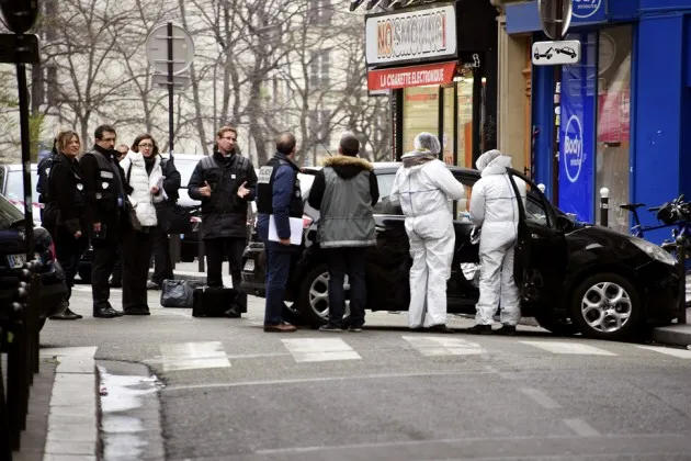 Police and forensic teams examine a car used by armed gunmen at the offices of satirical magazine Charlie Hebdo in Paris on Jan. 7.