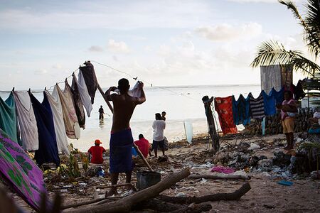 A man hangs out his laundry in Tarawa’s Bairiki Village, one of the most high-density slum areas in Kiribati