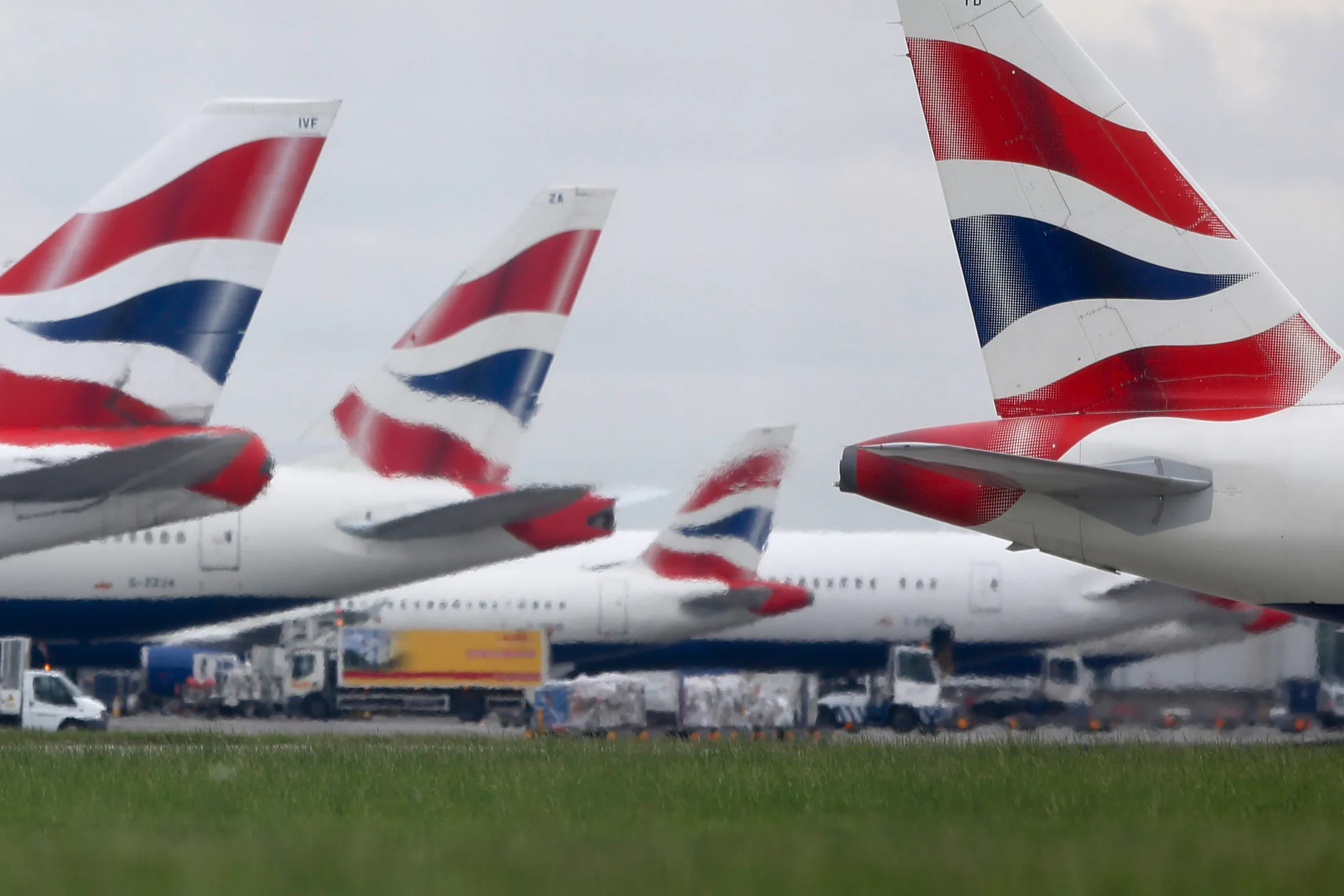 A passenger aircraft, operated by British Airways, a unit of International Consolidated Airlines Group SA (IAG), passes other British Airways passenger aircraft on the tarmac at London Heathrow Airport, in London, U.K., on Tuesday, May 30, 2017. British Airways' epic meltdown over a busy holiday weekend further fanned public outrage of an industry infamous for its focus on cost cuts over customer service, leaving the U.K. carrier scrambling to explain how a local computer outage could lead to thousands of stranded passengers.
