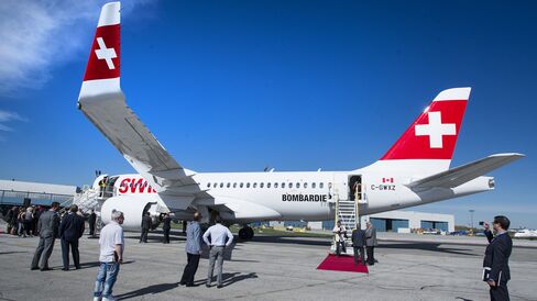 Attendees view the new Bombardier Inc. CS100 airplane during an event at the company's facility in Toronto, Ontario, Canada, on Thursday, Sept. 10, 2015. Bombardier Inc. is refocusing the sales campaign for its tardy CSeries jet on established, "marquee" airlines, a shift away from reliance on lessors and small carriers.