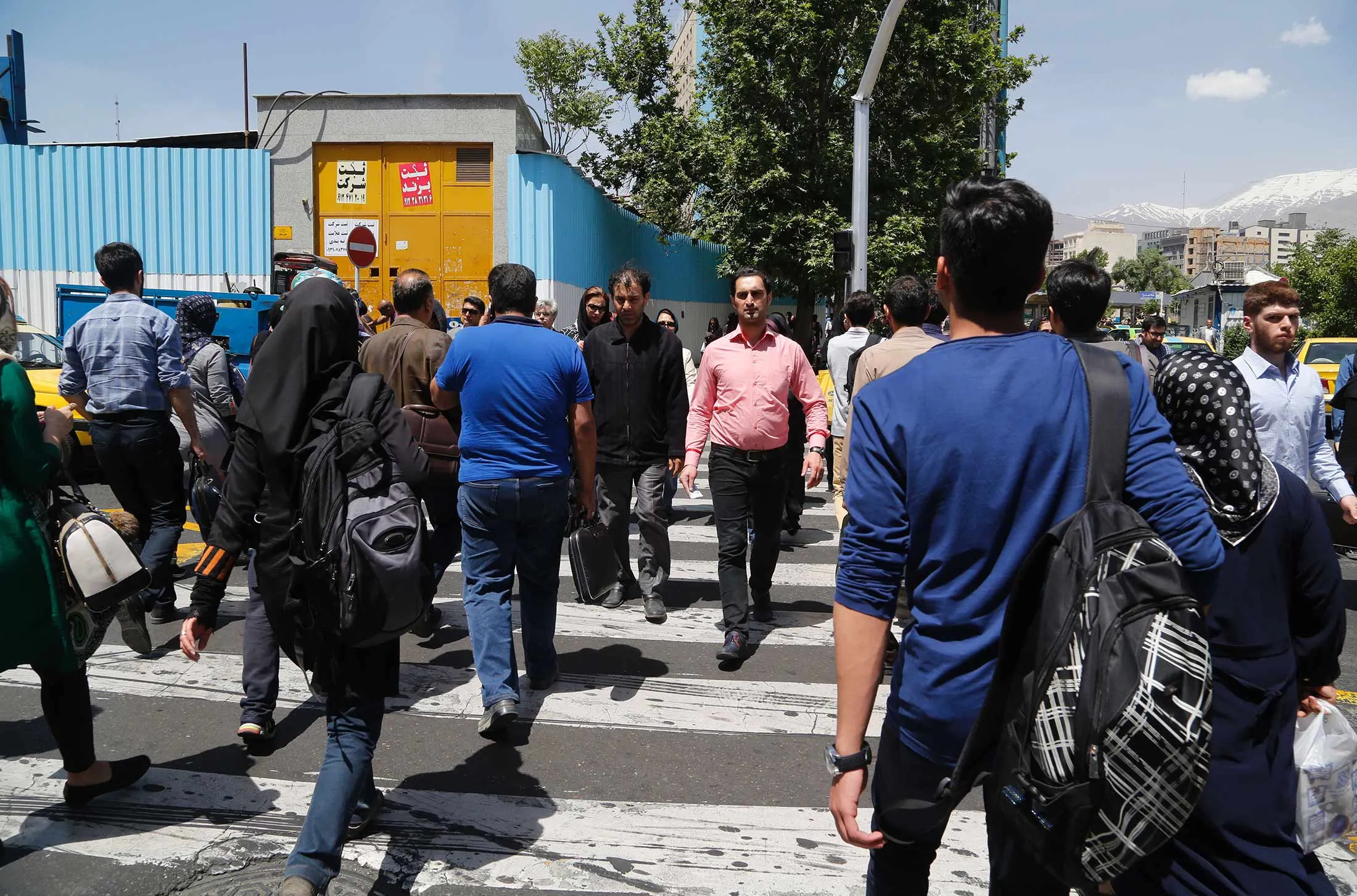 Iranians cross a road in downtown Tehran on April 27, 2016.

