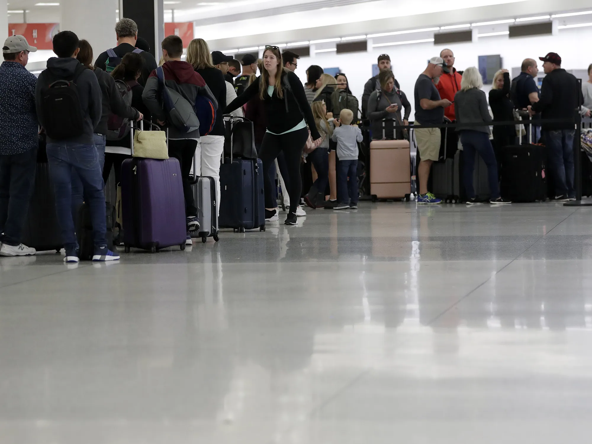 Passengers wait in line at Concourse G at Miami International Airport on Jan. 11
