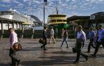 Commuters walk past the Circular Quay wharf in Sydney, Australia.
