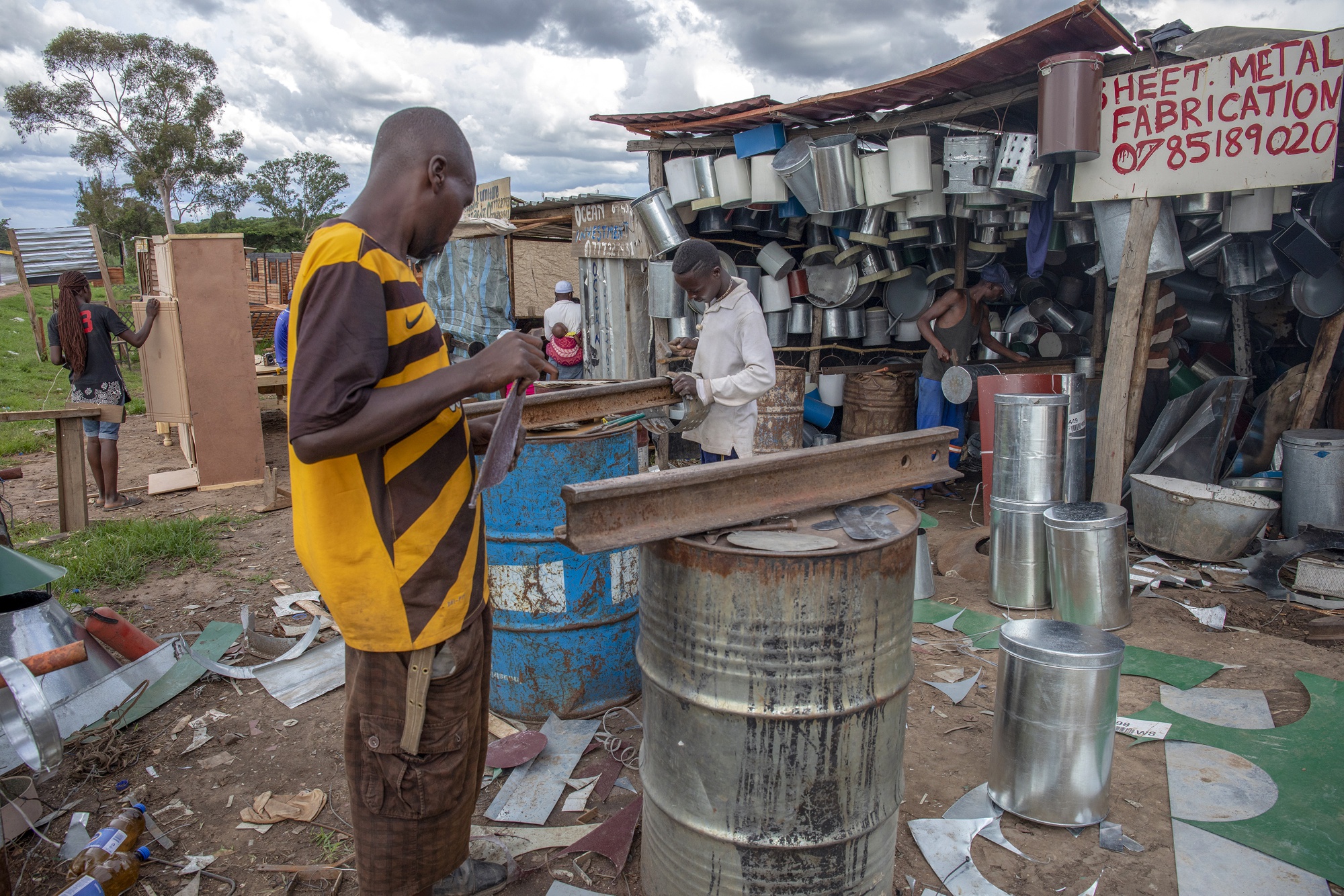 Workers prepare pieces of metal for resale at a scrap and sheet metal stall in Harare, Zimbabwe.