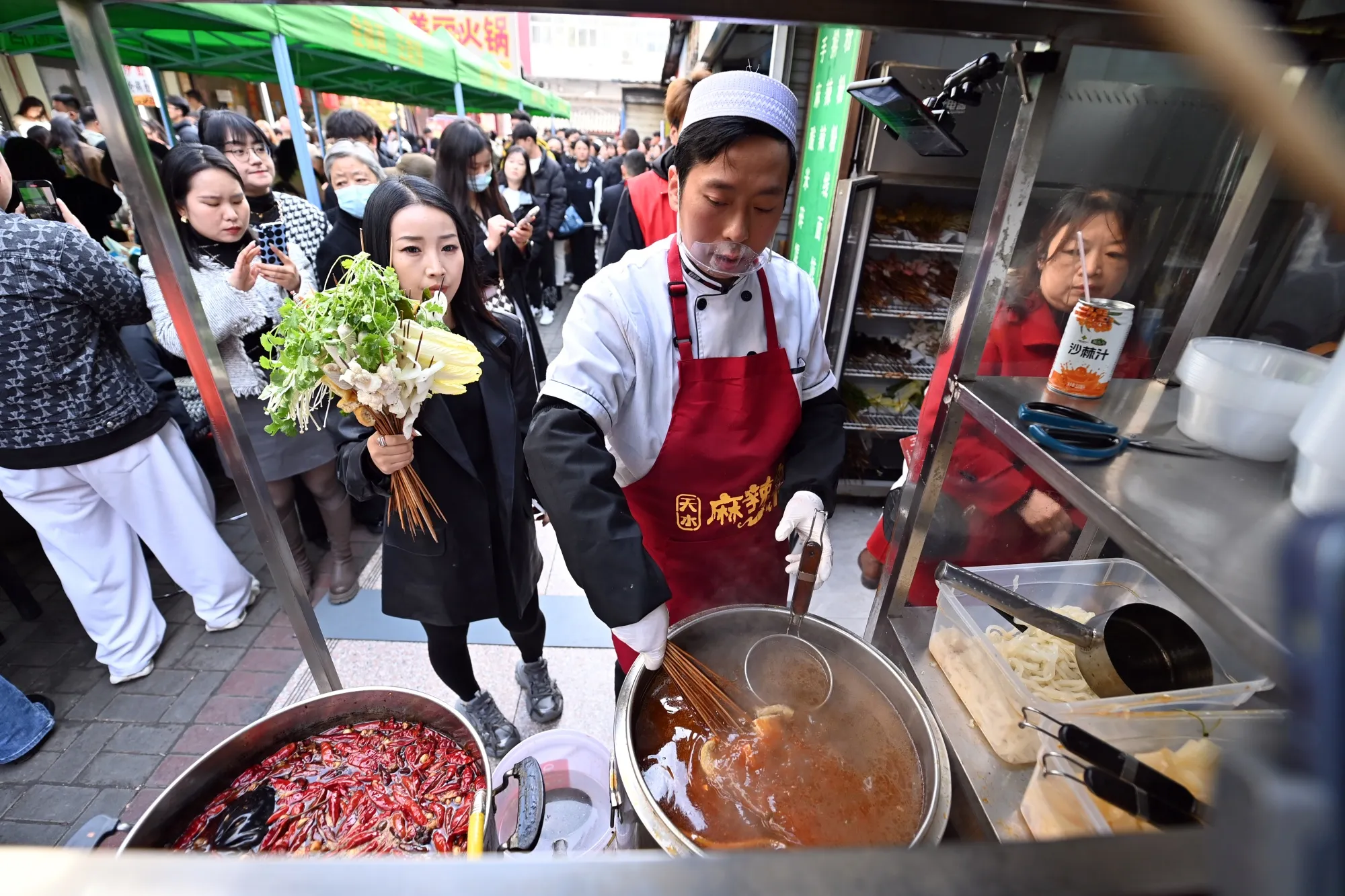 A staff member cooks Tianshui spicy hot pot in Gansu province on March 14.