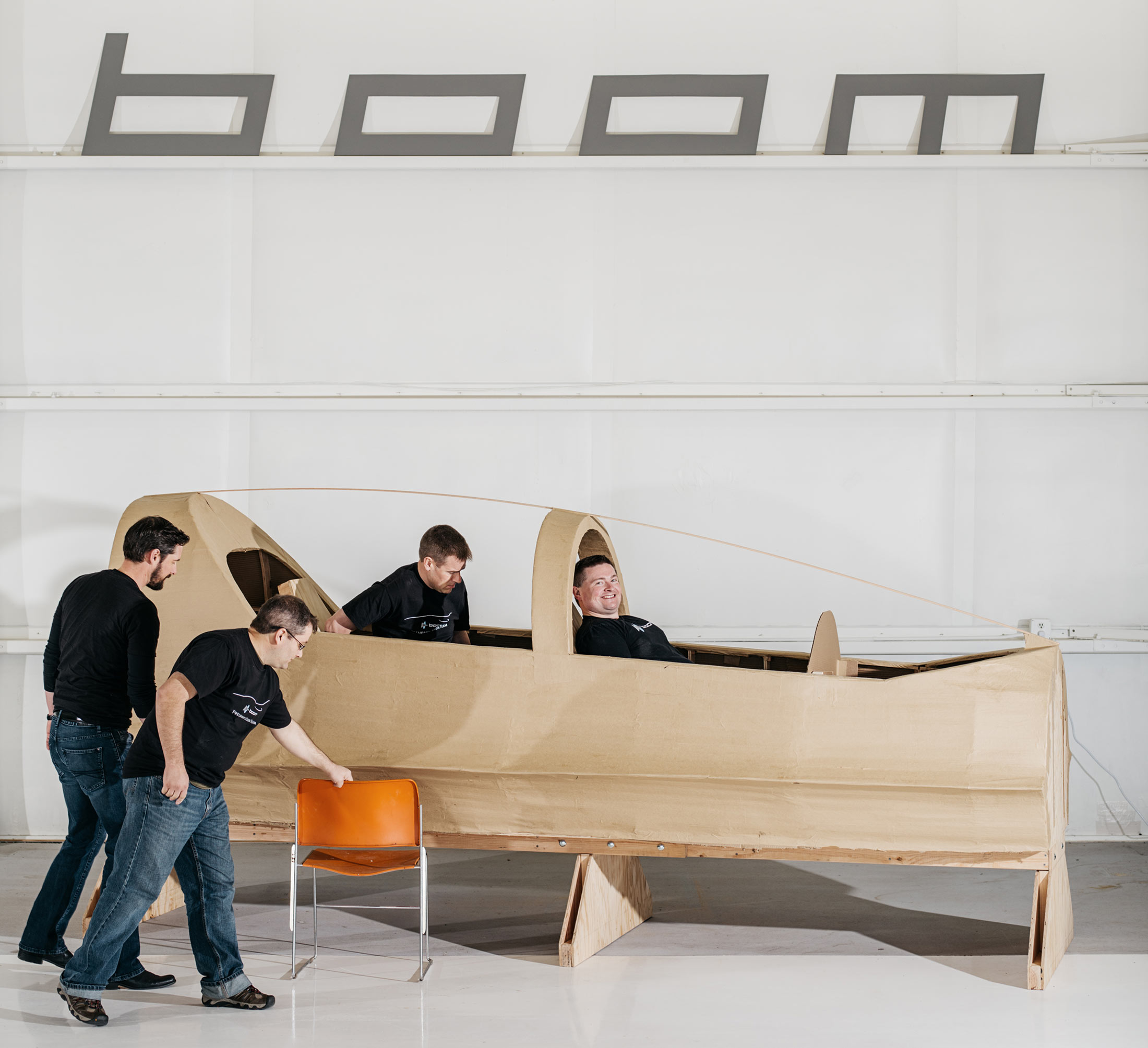 Joe Wilding, Boom’s chief engineer, and Blake Scholl, Boom’s founder and chief executive officer,  sit in a model of cockpit made from cardboard and plywood.

